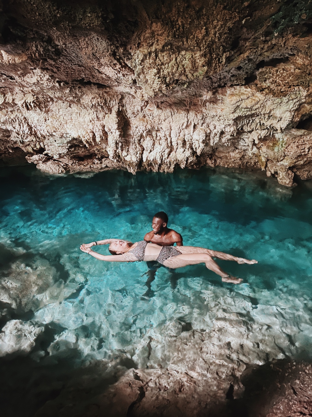 Swimmers inside Kuza Cave freshwater pool Zanzibar